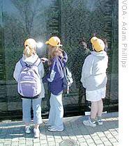 Children examine names of the dead at the Vietnam Veterans Memorial