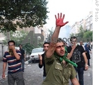In this photograph posted on the internet, a man holds up his hand covered in blood during clashes between demonstrators and riot police in Tehran, Iran