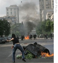 Supporters of opposition leader Mir Hossien Mousavi set fire to a barricade as they hurl stones during a protest in Tehran