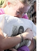 Fan cries while holding pillow with picture of Michael Jackson outside UCLA Medical Center, in Los Angeles, 25 Jun 2009