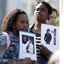 Fans hold pictures of Michael Jackson near the UCLA Medical Center in Los Angeles on Thursday