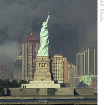 The Statue of Liberty on September 11, 2001. In the background smoke rises from the wreckage of the World Trade Center.