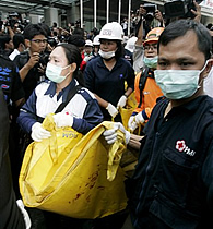 Rescuers evacuate the body of a victim of the bomb explosion outside J.W. Marriott hotel in Jakarta, Indonesia, 17 Jul 2009