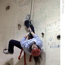 Dana Cooper hangs upside down on a climbing wall in her P.E. class at Northport High School in New York State